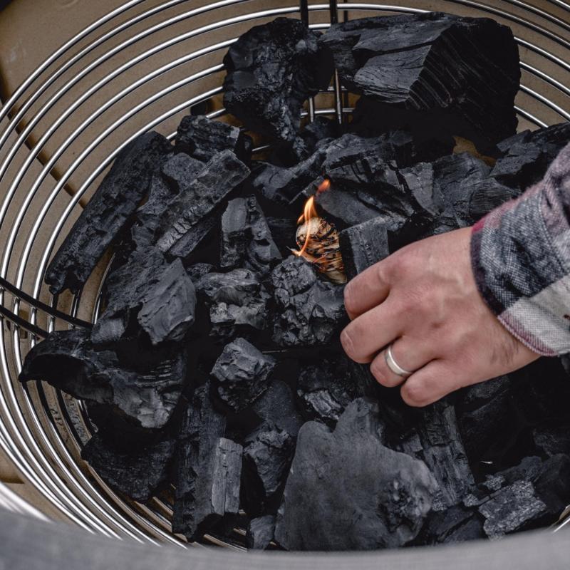 lighting charcoal in a charcoal basket in a big joe